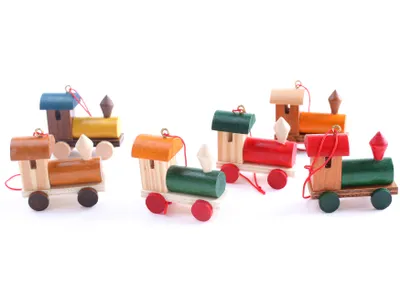 A collection of small, wooden train ornaments arranged on a white background.