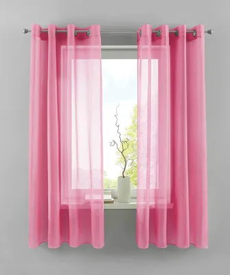 A window with pink curtains and sheer overlays, with a white vase and decorative branches on the windowsill.