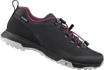 A single black Shimano cycling shoe with purple accents and a white sole, shown from a side-diagonal angle against a white background.