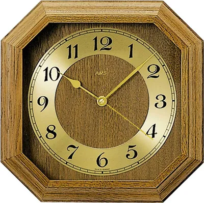 A close-up view of an octagonal wall clock with a wooden frame and a gold face.