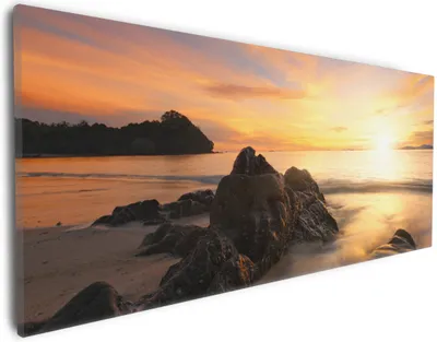 Produktbild von Wallario Premium Leinwandbild Sonne über dem Meer mit Felsenlandschaft in Größe 30 x 75 cm