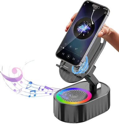 A hand holding a smartphone mounted on a black speaker stand with colorful LED lights.