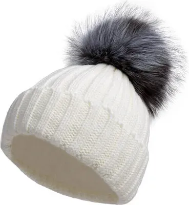 Weiße Strickmütze mit großem flauschigen grau-schwarzen Kunstfell-Pompon oben, aus leichtem Winkel betrachtet