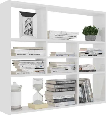A white bookshelf filled with books, a picture frame, and a plant.