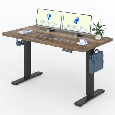 A standing desk with two monitors, a keyboard, a mouse, headphones, a cup of coffee, and a bag hanging from the side.