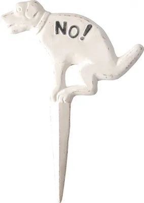 A white garden stake shaped like a dog in a squatting position with the word "NO!" on its back.