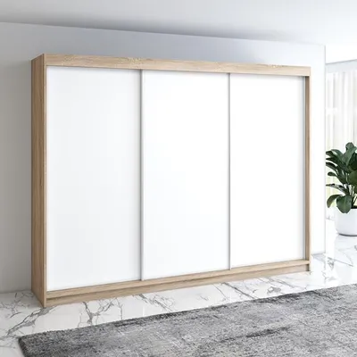 A modern, three-door sliding wardrobe with a light wood frame and white doors, set against a light gray wall and a marble-effect floor with a rug in the foreground.