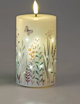 A decorative LED candle with a floral and butterfly design.