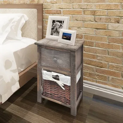 A bedside table next to a bed, with a brick wall in the background.