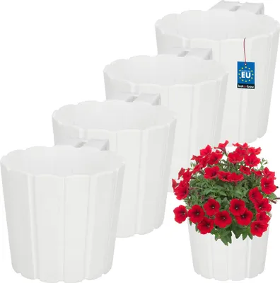 A set of four white hanging planters of varying sizes, with one planter in the foreground containing red petunias.