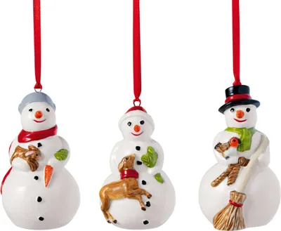 Three ceramic snowman ornaments hanging from red ribbons against a white background.