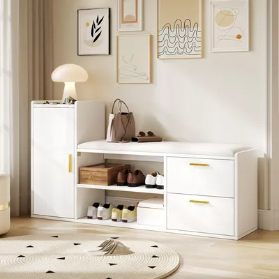 A white shoe cabinet with storage and a padded bench, displayed in a well-lit room with artwork on the wall.