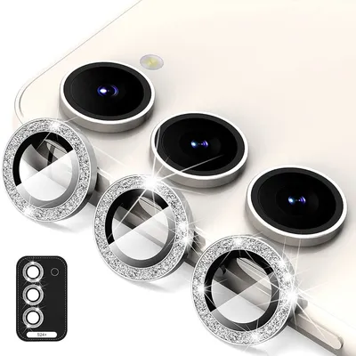 Close-up view of multiple camera lens protectors with glittery rims, arranged on a white surface.