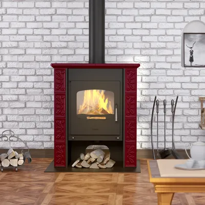 A wood-burning stove with a red decorative surround, set against a white brick wall and wooden floor.