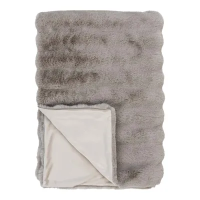 A folded faux fur blanket on a white background.