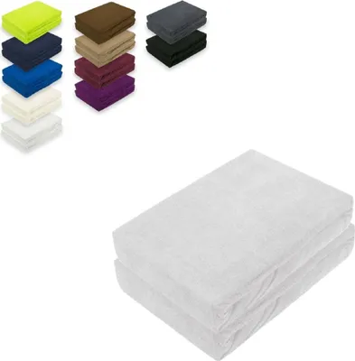 A collage of folded fabric items in various colors, with a larger view of two white folded items in the foreground.