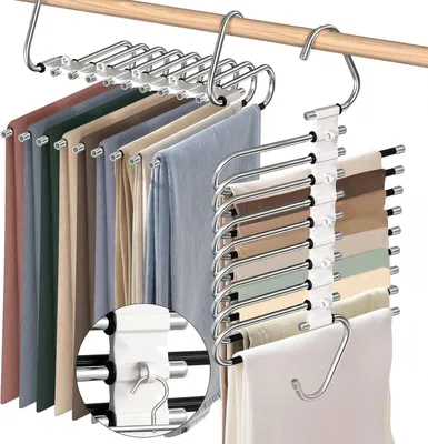 Multiple pairs of pants are hung on S-shaped hangers attached to a wooden rod.