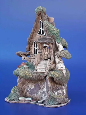 Eine Keramik-Skulptur, die ein auf einem Felsen sitzenden Drachenforst darstellt. Erdige Farbpalette