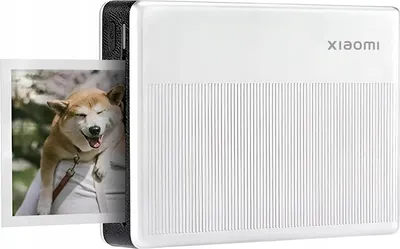 A white Xiaomi portable photo printer with a printed photo of a dog emerging from the slot.