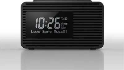 A black digital alarm clock with a display showing the time and song title.