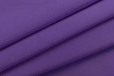 A close-up view of folded purple fabric, likely curtains, with soft lighting.