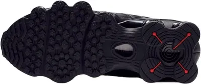The image shows the sole of a black Nike Shox TL sneaker with orange accents.