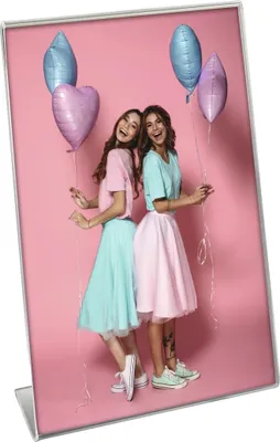 Two young women are posing with balloons.