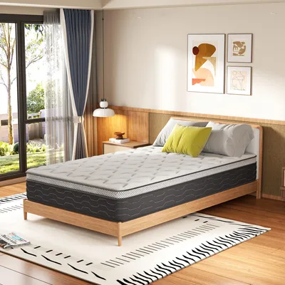 A bedroom scene with a mattress on a bed frame, next to a nightstand and window.