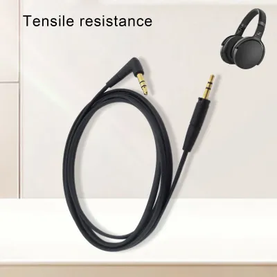 A black audio cable with gold connectors is shown, with a pair of headphones in the background.