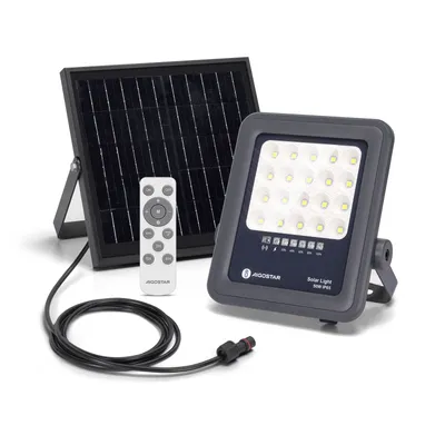 A solar floodlight with its solar panel and remote control are displayed against a white background.