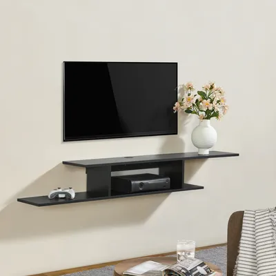 A black wall-mounted TV shelf with a TV, a game controller, and a media box.