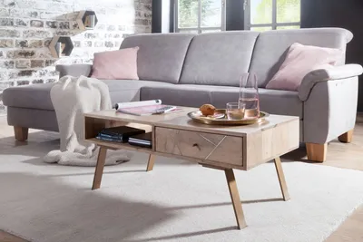 A living room scene featuring a sectional sofa, coffee table, and decorative elements.