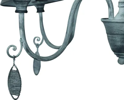 A close-up view of a decorative chandelier arm with a hanging ornament.