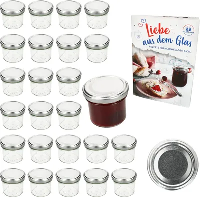 A set of small glass jars with silver lids, a single jar filled with red jam, and a recipe book, all arranged on a white background.