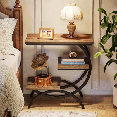 A bedside table with decorative items next to a bed.