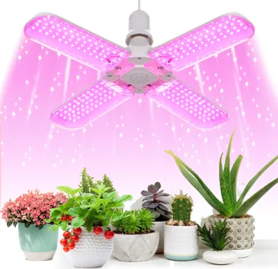 A pink LED grow light is shown above a collection of potted plants.