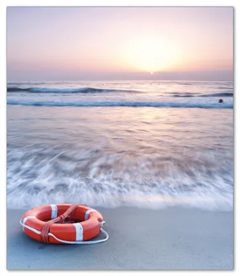 Produktbild von Wallario Herdabdeckplatte aus Glas, Größe 52 x 60 cm 1-teilig, Motiv Rettungsring am Strand bei Sonnenuntergang