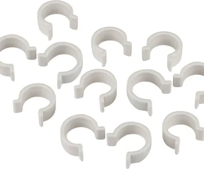A collection of white plastic clips arranged on a white background.