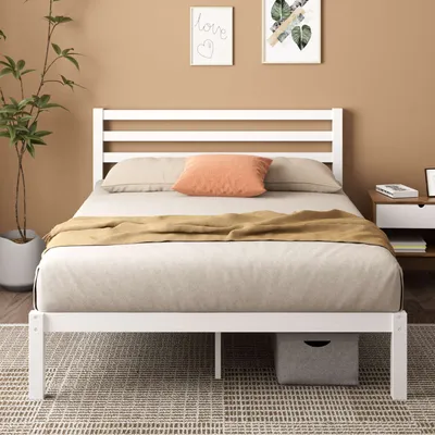 Weißes Holzlattenbett mit Matratze und Box im gemütlichen Schlafzimmer.