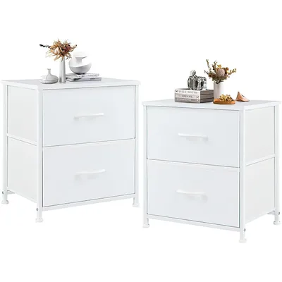 Two white two-drawer nightstands are shown against a white background, each with decorative items on top.