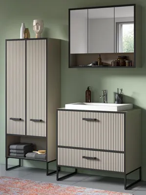 A bathroom vanity and cabinet set against a green wall.