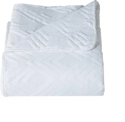 A folded white blanket with a geometric pattern.