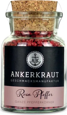 A glass jar filled with pink peppercorns, sealed with a cork stopper and featuring a label.
