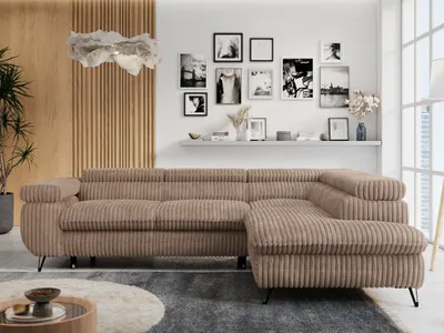 A modern living room with a large sectional sofa, a wall with framed pictures, and a unique light fixture.