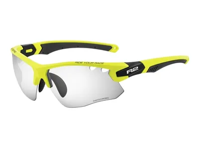A pair of neon green and black cycling glasses with clear photochromic lenses, shown against a white background.
