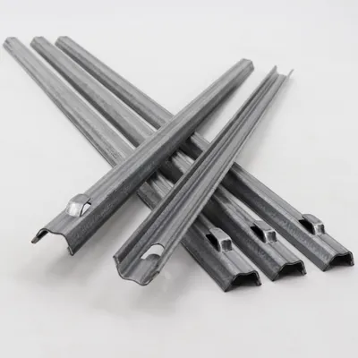 A pile of metal fence anchors on a white background.