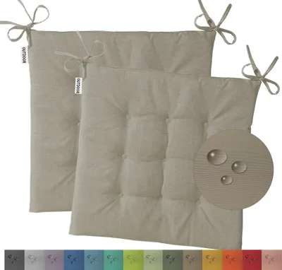 Two beige outdoor seat cushions with ties and tufting, shown on a white background. A circular inset highlights water droplets on the fabric.