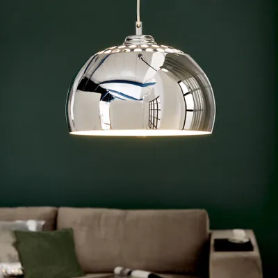 A modern living room with a couch and a hanging lamp.