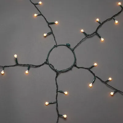 Imagen del producto de Guirnalda LED Konstsmide para árboles, con aro de 11 cm de diámetro, con bombillas esféricas, 5 cadenas de 30 diodos cada una, preensamblada, 150 diodos ámbar, transformador interno de 30V, cable verde.- 6367-820