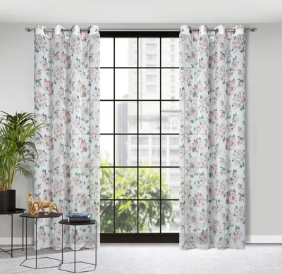 A pair of floral patterned curtains hanging in front of a large window with a city view.